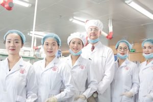Team of healthcare workers in a laboratory wearing uniforms and safety gear.